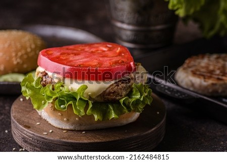 Burger on a wooden board, open burger without top bun