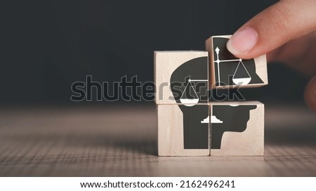 Ethics inside human mind, Business ethics concept. Hand hold ethics inside a head symbols in wooden cubes on dark background with copy space. Royalty-Free Stock Photo #2162496241