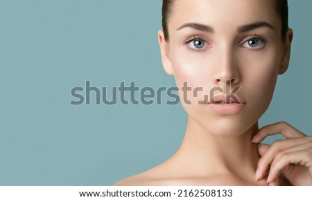 Beautiful young women with perfect fresh skin and makeup touches her face. Portrait of model with make-up, eyebrows  and long eyelashes. Beauty and Spa, skincare and wellness. Selective focus Royalty-Free Stock Photo #2162508133