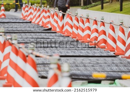 Sidewalk detour in progress. Row of orange cones placed on sidewalk during road maintenance.
