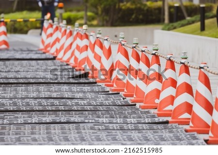 Sidewalk detour in progress. Row of orange cones placed on sidewalk during road maintenance.