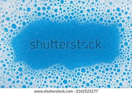 Soap foam close-up. Background from soapy bubbles of shampoo in blue color