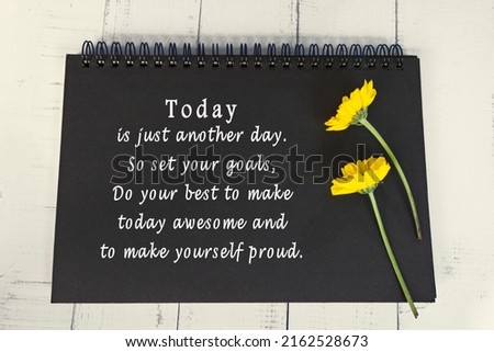 Motivational and inspirational quote on black note book with sunflowers on wooden desk - Today is just another day, so set your goals do your best to make today awesome and to make yourself proud.