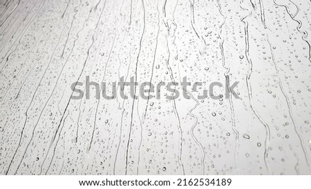 background raindrops on the clear window. a small raindrop rests on the glass after rain. Royalty-Free Stock Photo #2162534189