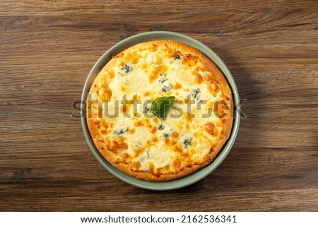 Quattro Formaggi Pizza served in a dish top view on dark wooden background