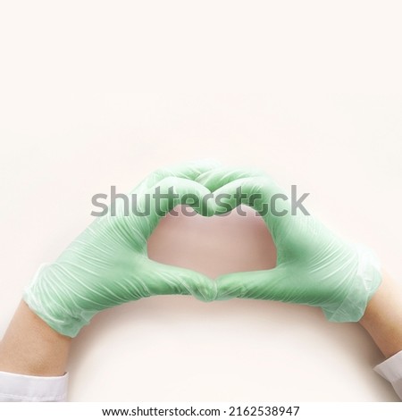 Heart in Medical glove. Surgery doctor hand. Medicine healthcare operation equipment. Specialist clean hospital arm. Sanitation protection gesture. Sterile hygiene concept. Green color