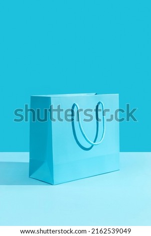 Paper shopping bag on blue background. Shopping sale delivery concept Royalty-Free Stock Photo #2162539049