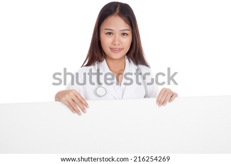Young Asian female doctor standing behind blank white billboard