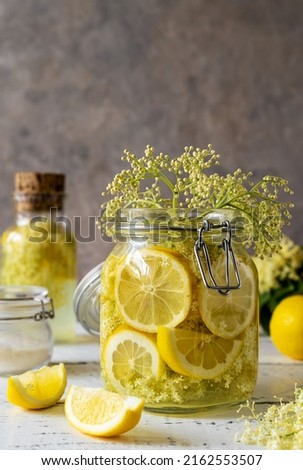 Elderberry infused watering or syrup in jar and bottle made with fresh flowers and lemons as main ingredients. vertical banner. Selective focus Royalty-Free Stock Photo #2162553507
