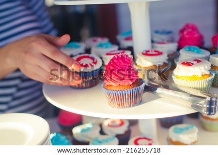 Beautiful multicolored decorated baked sweet tasty cupcake cupcakes with buttercream on a party with happy people around 