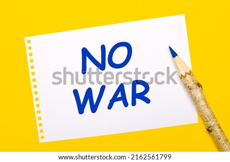 On a bright yellow background, a large wooden pencil and a white sheet of paper with the text NO WAR