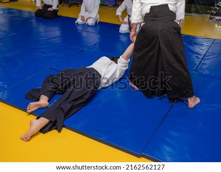 Aikidoka uses the technique joint lockon the opponent during the training of aikido Royalty-Free Stock Photo #2162562127