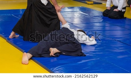 Aikidoka uses the technique joint lockon the opponent during the training of aikido Royalty-Free Stock Photo #2162562129