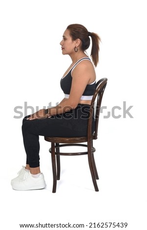 side view of women sitting on chair with sportswear on white background
