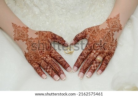 Henna tattoo on the bride's hand. Heart shaped hand. With a wedding ring in the middle Royalty-Free Stock Photo #2162575461