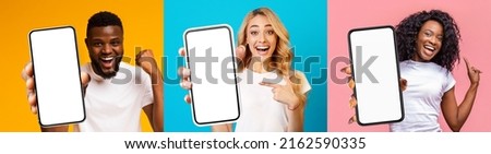 Positive multiracial millennials two ladies and guy holding smartphones with white blank screens, posing on colorful studio backgrounds, wearing white t-shirts, set of photos, collage, panorama