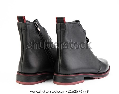 Women's autumn black and red leather jodhpur boots isolated on white background. Back side view. Fashion shoes. Photoshoot for shoe shop concept.