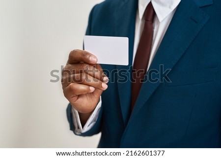 Selective focus of business card in hand of african american businessman. Partial image of man wearing suit. Modern successful male lifestyle. Isolated on white background. Studio shoot. Copy space