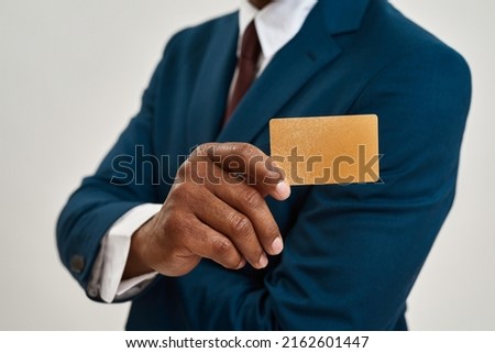 Selective focus of golden business card in hand of blurred african american ceo manager or entrepreneur. Man wearing suit. Concept of modern successful male lifestyle. White background. Studio shoot