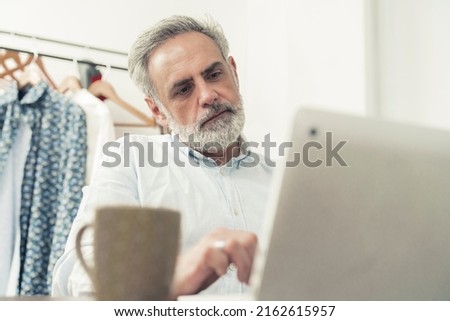 Gray haired bearded male enterprenuer looking to the camera, isolated. High quality photo