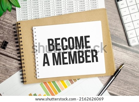 stickers, plant, pen and a white notebook with the text BECOME A MEMBER