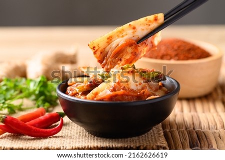 Kimchi cabbage eating by chopsticks, Korean homemade fermented side dish food Royalty-Free Stock Photo #2162626619