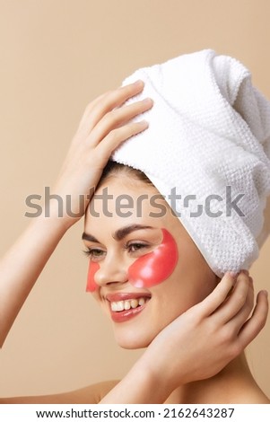 woman pink patches on the face with a towel on the head isolated background