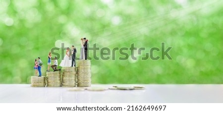 Financial dependency for family life or married life concept : Miniature figurine young couple on coins, depicting investment or savings money for future expense or obligations for a newly wed family. Royalty-Free Stock Photo #2162649697