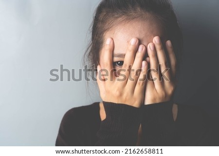 Phobia, the girl hides her face with her hands and peeks into the gap between her fingers. specific phobia, agoraphobia. 