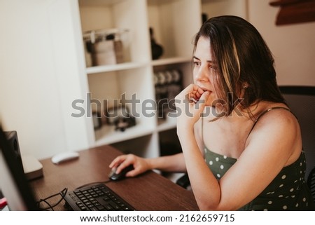 Woman working on her computer in her home office