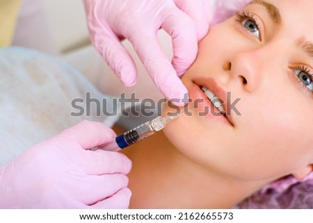 Image of a young beautiful woman dressed as a patient, lying on a couch in a cosmetology clinic. Royalty-Free Stock Photo #2162665573