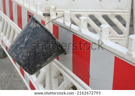 Road construction, a bucket hangs on a barrier