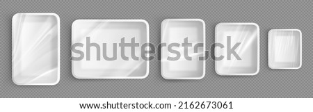 White plastic trays for food, empty styrofoam containers with transparent film wrapper. Vector realistic mockup of 3d polystyrene package for lunch, meal and fresh products Royalty-Free Stock Photo #2162673061