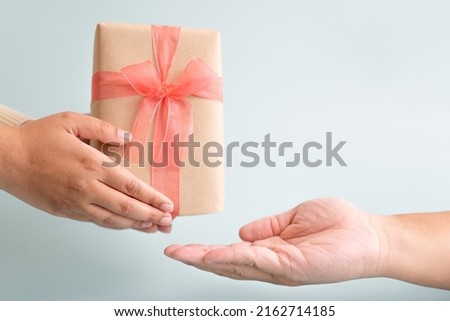 Sending and receiving gift with ribbon bow for special occation to someone you love. Holidays seasonal to give and to take gift box surprised.
