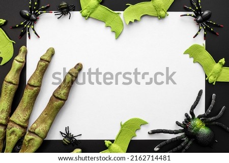 Halloween mock up, blank white sheet of paper with spiders, bats and monsters hand on a black background. Happy Halloween concept.