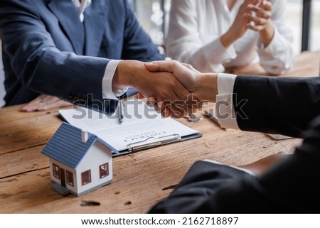 Real estate brokerage agent Deliver a sample of a model house to the customer, mortgage loan agreement Making lease and buy and sell house And contract home insurance mortgage loan concept Royalty-Free Stock Photo #2162718897