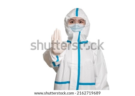 Doctor or nurse wearing protective suit and mask showing stop gesture on the white background.
