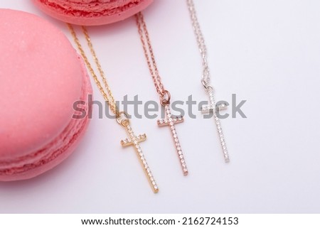Silver cross necklace decorated with macarons. Image for e-commerce, online selling, social media, jewelry sale.