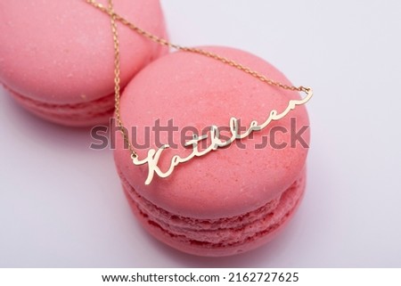 A personalized silver name necklace image on a macaron decorated background. Image for e-commerce, online selling, social media, jewelry sale.