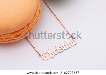 A personalized silver name necklace image on a macaron decorated background. Image for e-commerce, online selling, social media, jewelry sale.