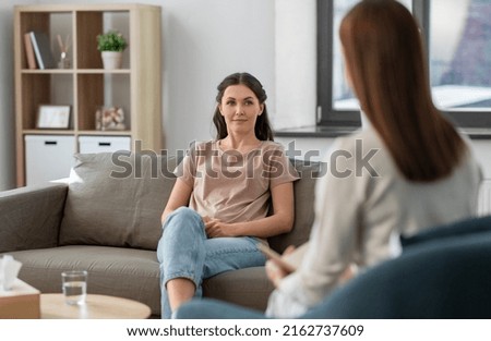 psychology, mental health and people concept - young woman patient and woman psychologist at psychotherapy session Royalty-Free Stock Photo #2162737609
