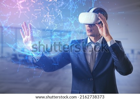 Attractive young european businessman in VR glasses using global polygonal interface on blurry office interior background. Metaverse and augmented reality concept. Double exposure Royalty-Free Stock Photo #2162738373