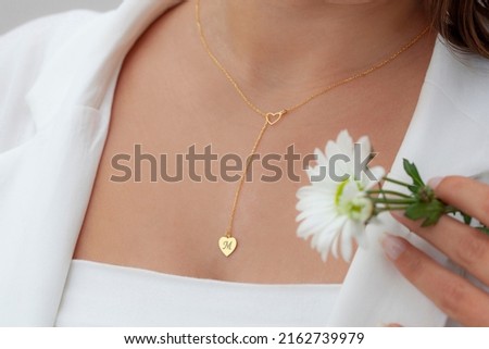 Personalized silver necklace on a female model wearing a white dress. Image for ecommerce, online selling, social media, jewelry sale.