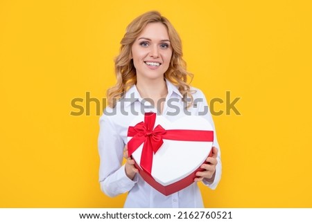 woman smile hold present heart box on yellow background