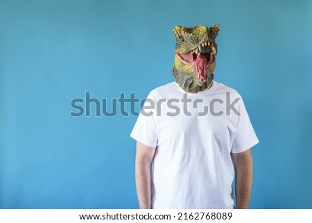 Funny laughing dinosaur head on human body on white t-shirt on blue background. Clip art, negative space.