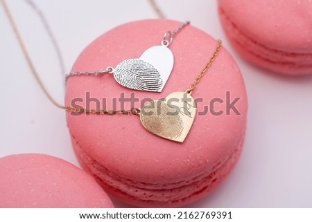 Personalized necklace with silver, gold and rose fingerprints on the macarons. Image for e-commerce, online selling, social media, jewelry sale.