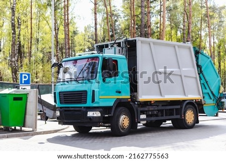 A garbage truck picks up garbage in a residential area. Loading mussar in containers into the car. Separate collection and disposal of garbage. Garbage collection vehicle Royalty-Free Stock Photo #2162775563