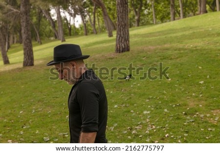 Side view of adult man in hat in park
