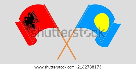Crossed and waving flags of Albania and Palau. Vector illustration
