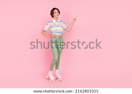 Full body photo of young girl happy smile roller skater point finger empty space ad choice isolated over pink color background